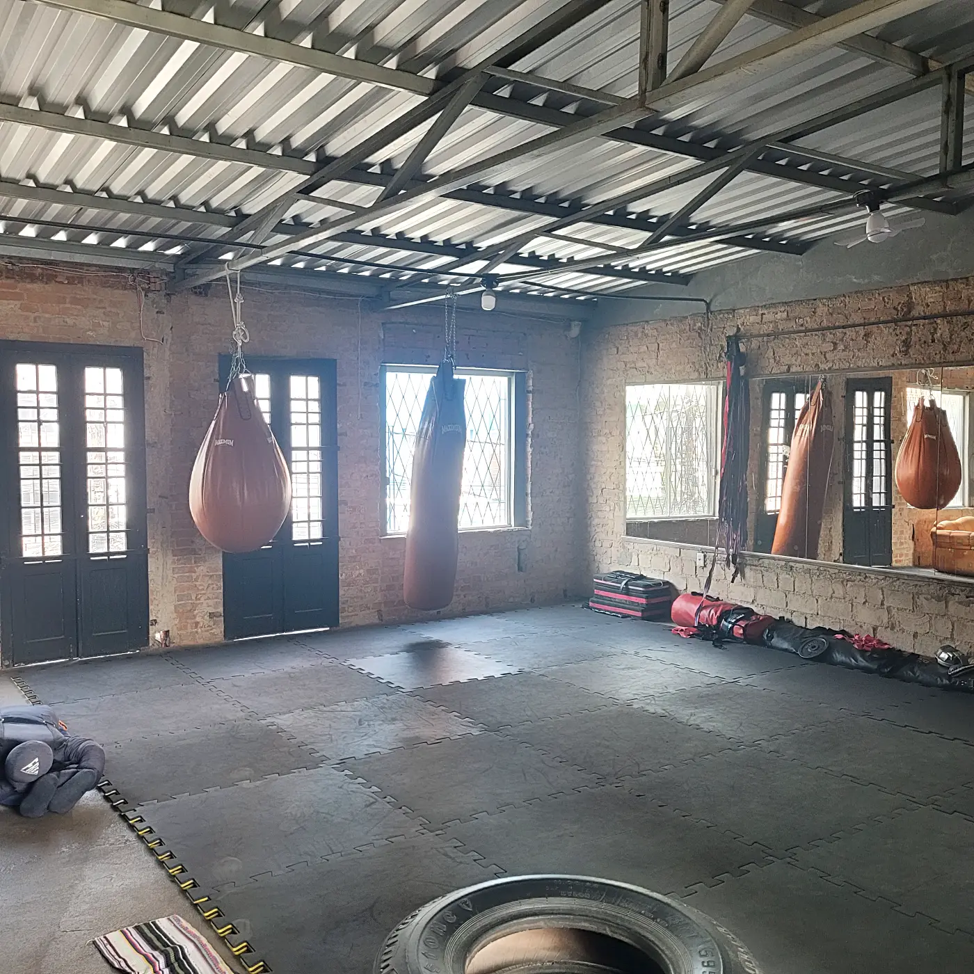 Sacos de pancada de couro e portas de madeira na área de muay thai